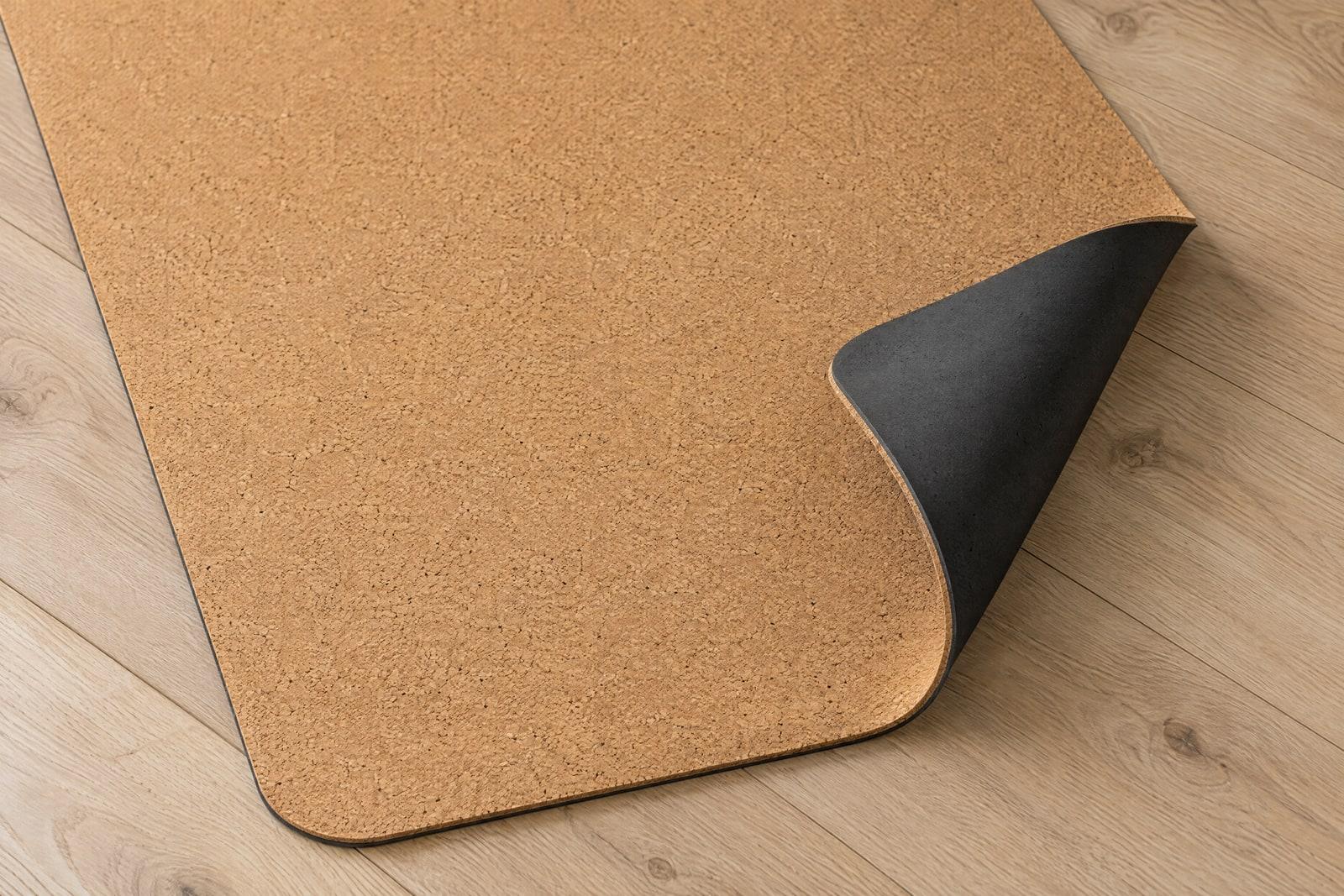 One corner of the mat folded back to show the charcoal rubber underside.