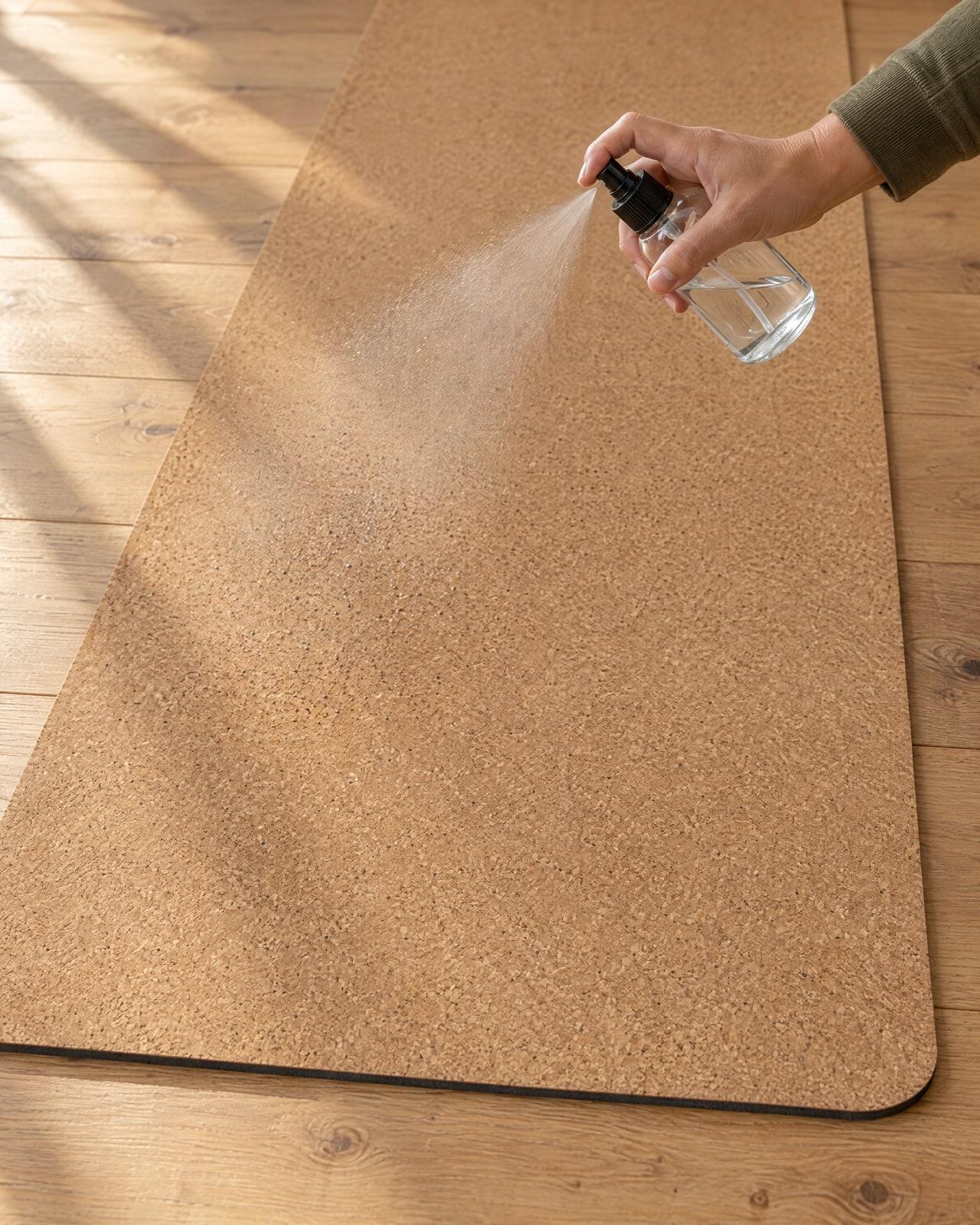 A hand misting the cork surface with the glass mister.
